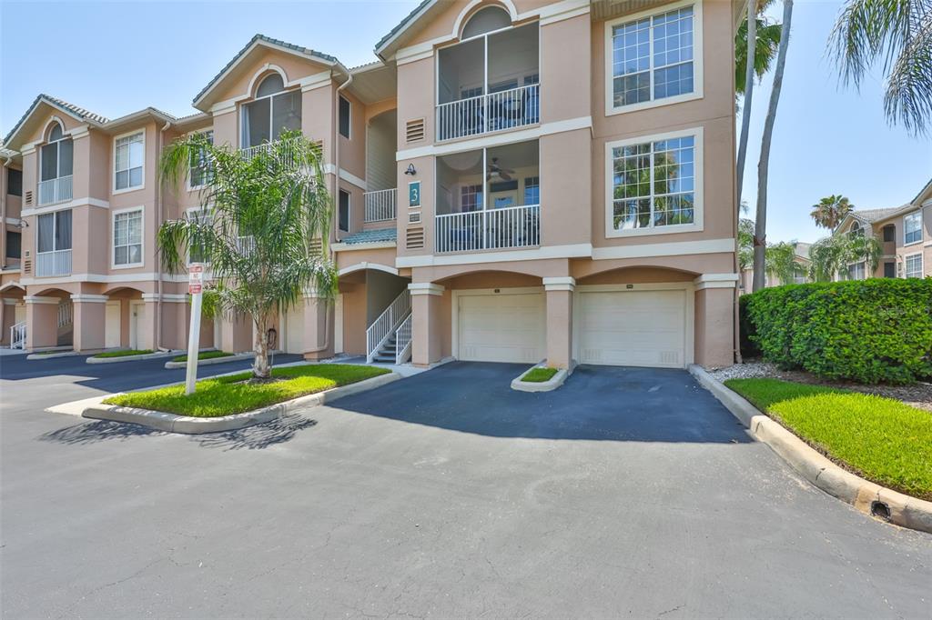 Exterior view of a multi-story apartment building with attached garages and screened balconies — 3312 BAY CLUB CIRCLE UNIT 3312, TAMPA, FL