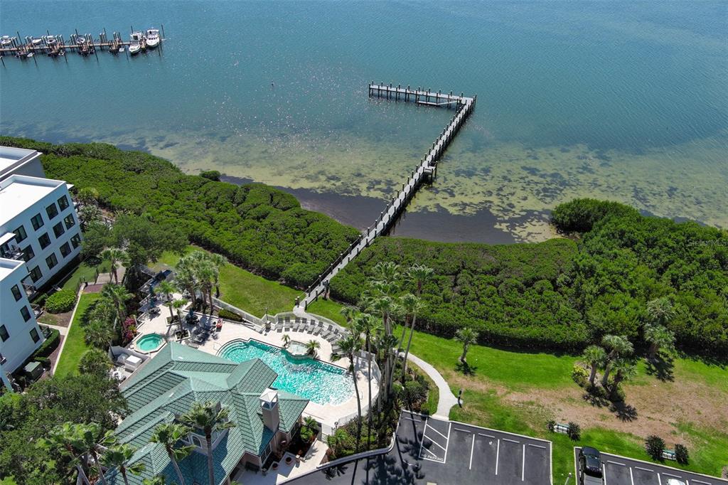 An aerial view shows a swimming pool, a long wooden pier, and a parking lot — 3312 BAY CLUB CIRCLE UNIT 3312, TAMPA, FL