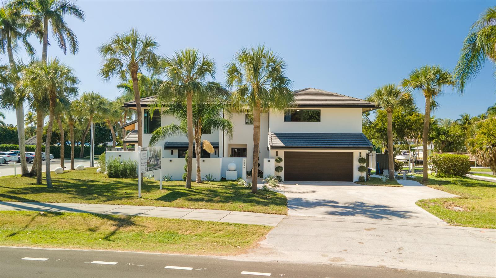 A two-story white house with a dark roof, a garage, and palm trees in the yard — 1690 S Ocean Boulevard, Delray Beach FL 33483, DELRAY BEACH, FL