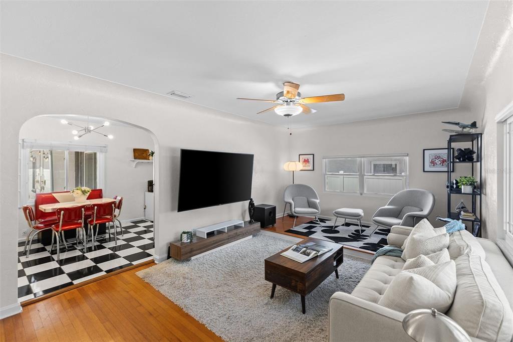 A living room with hardwood floors, a white rug, and an arched entryway to a dining area — 170 22ND AVENUE N, ST PETERSBURG, FL