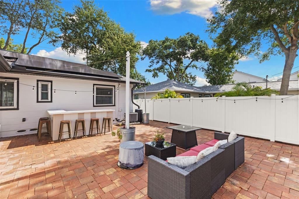 A paved backyard patio features an outdoor bar, seating area, and white vinyl privacy fence — 170 22ND AVENUE N, ST PETERSBURG, FL