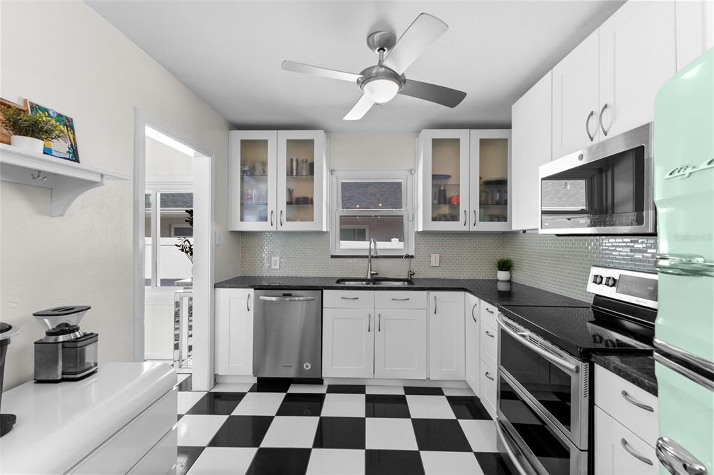 A kitchen features white cabinets, black countertops, a checkered floor, and a retro refrigerator — 170 22ND AVENUE N, ST PETERSBURG, FL