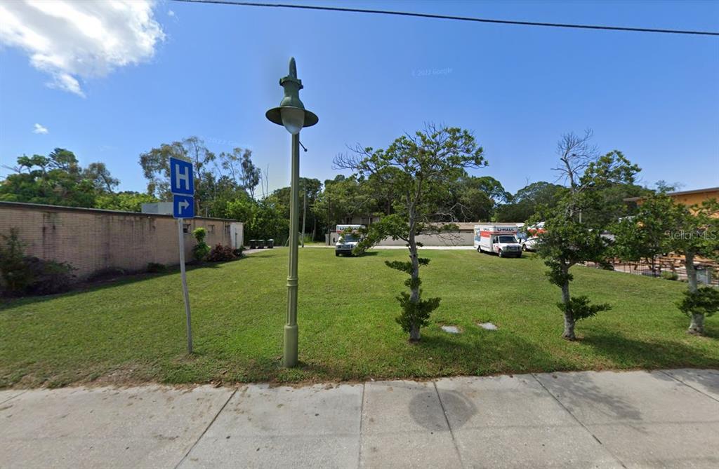 A vacant grassy lot features a street lamp, a hospital sign, and parked U-Haul trucks — 101 CLEARWATER-LARGO ROAD, LARGO, FL