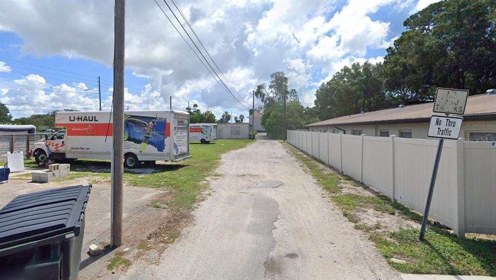 A gravel alleyway runs between a white fence and a parked U-Haul truck — 101 CLEARWATER-LARGO ROAD, LARGO, FL