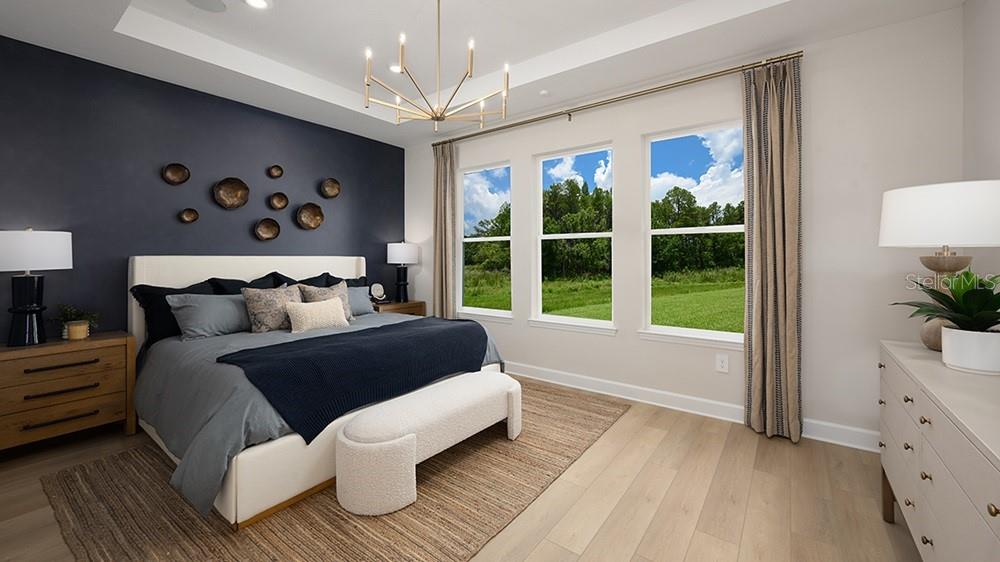A bedroom features a dark accent wall, a bed with neutral bedding, and three large windows — 12711 DOCKYARD TRAIL, PALMETTO, FL