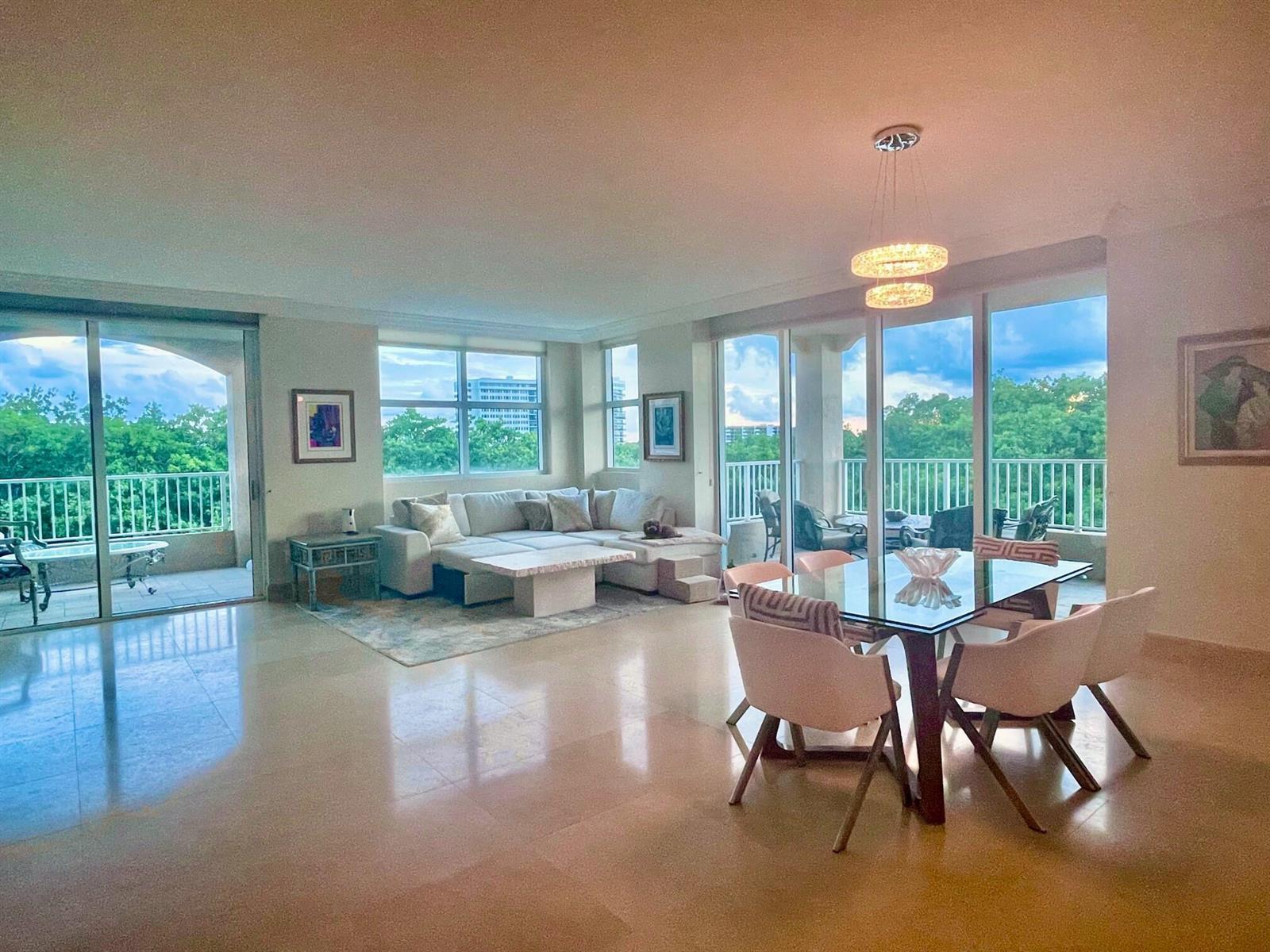 A bright, open-concept living and dining area with floor-to-ceiling windows and a balcony — 3720 S Ocean Boulevard # 301b, Highland Beach FL 33487, HIGHLAND BEACH, FL