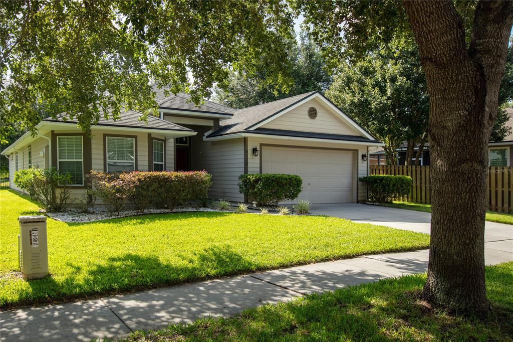 A single-story house with beige siding, a two-car garage, and a front lawn — 8123 NW 51ST DRIVE, GAINESVILLE, FL