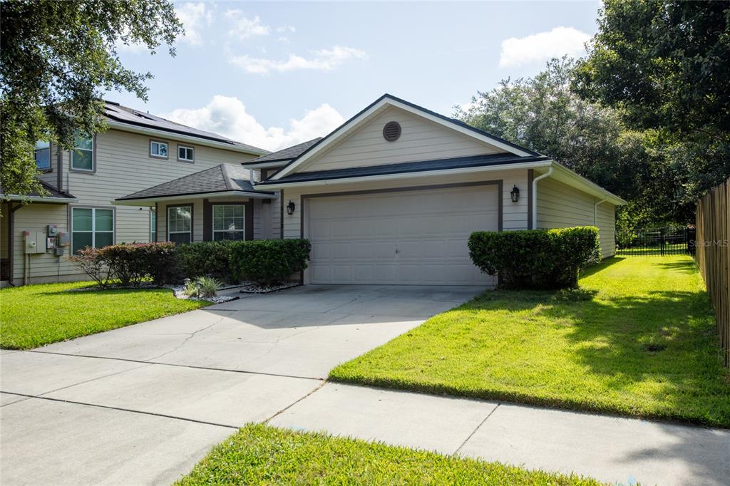 A tan, two-story suburban house with a two-car garage and a concrete driveway — 8123 NW 51ST DRIVE, GAINESVILLE, FL