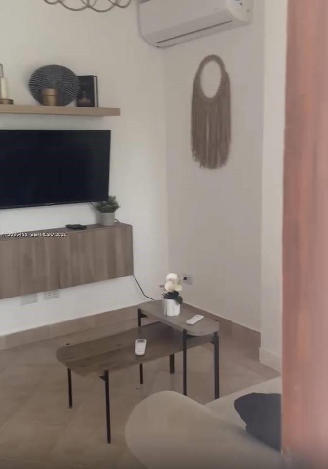 A living room features a wall-mounted television, floating wooden console, and a tiered coffee table — 23000 ciudad las canas # 0, FL