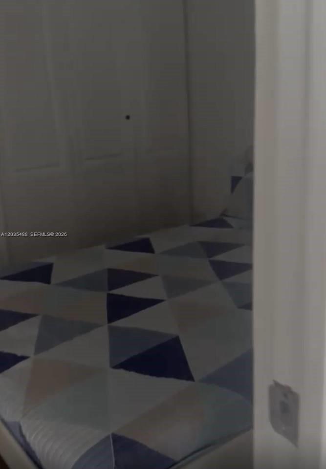 A bedroom features a bed with a geometric patterned comforter and a white closet — 23000 ciudad las canas # 0, FL