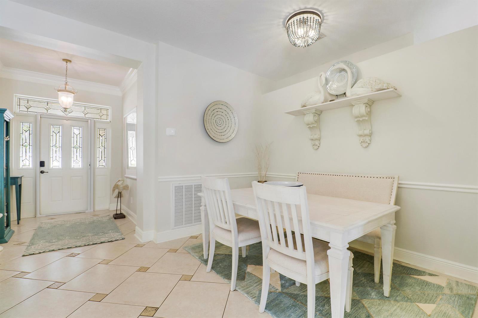 A dining area with a white table, chairs, bench, and a wall-mounted shelf with decor — 654 NE Little Kayak Point, FL 34983, FL