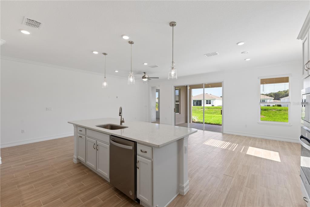 A kitchen island with a stainless steel dishwasher sits in an open-concept room with tile — 4559 NW 53RD AVENUE ROAD, OCALA, FL