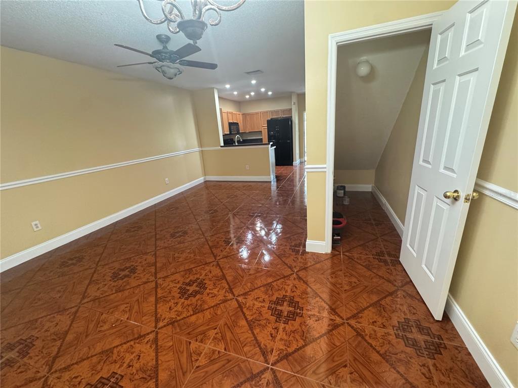 An open-concept living and dining area features glossy patterned tile flooring and a kitchen beyond — 6229 OSPREY LAKE CIRCLE, RIVERVIEW, FL