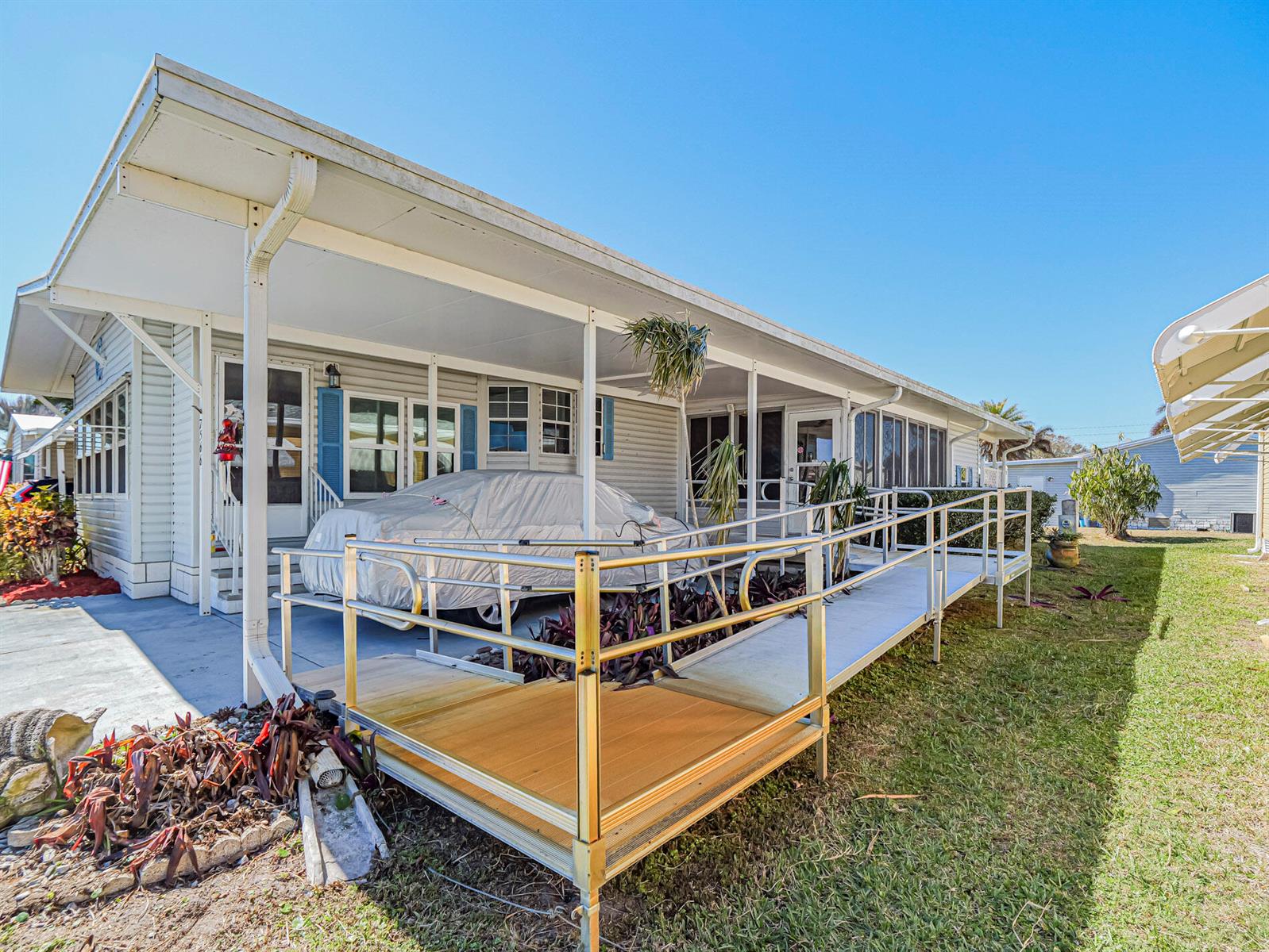 A mobile home exterior features a covered carport, a wheelchair ramp, and a car cover — 7566 Montauk Avenue # U19, FL 32976, FL