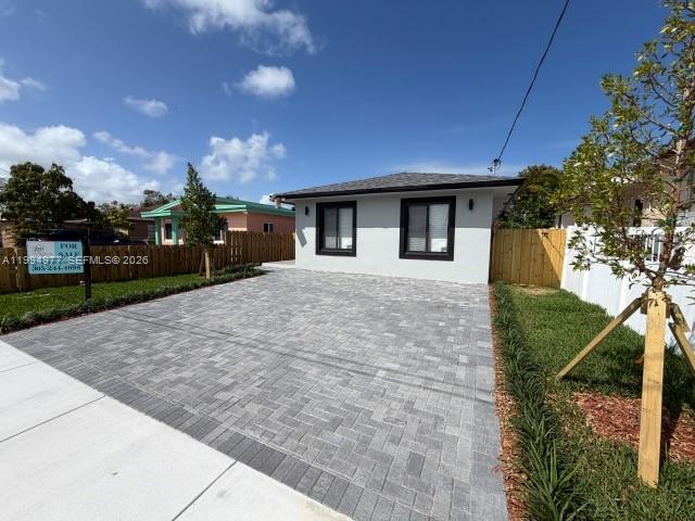 A single-story house with a gray paver driveway and a white fence — 644 NW 6th Ct, Hallandale Beach FL 33009, HALLANDALE BEACH, FL