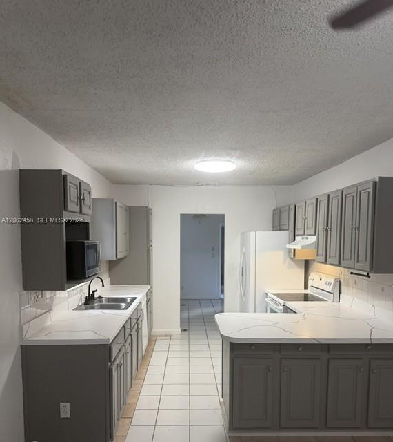 A kitchen features gray cabinets, white countertops with dark veining, and white tile flooring — 19920 SW 118th Pl # 0, Miami FL 33177, MIAMI, FL