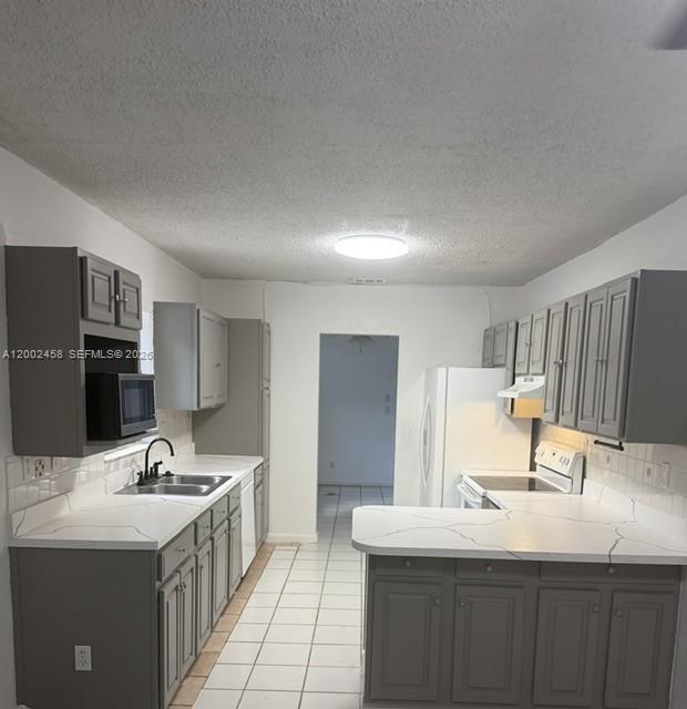 A single-story house with a chain-link fence and a paved driveway sits behind a lawn — 19920 SW 118th Pl # 0, Miami FL 33177, MIAMI, FL