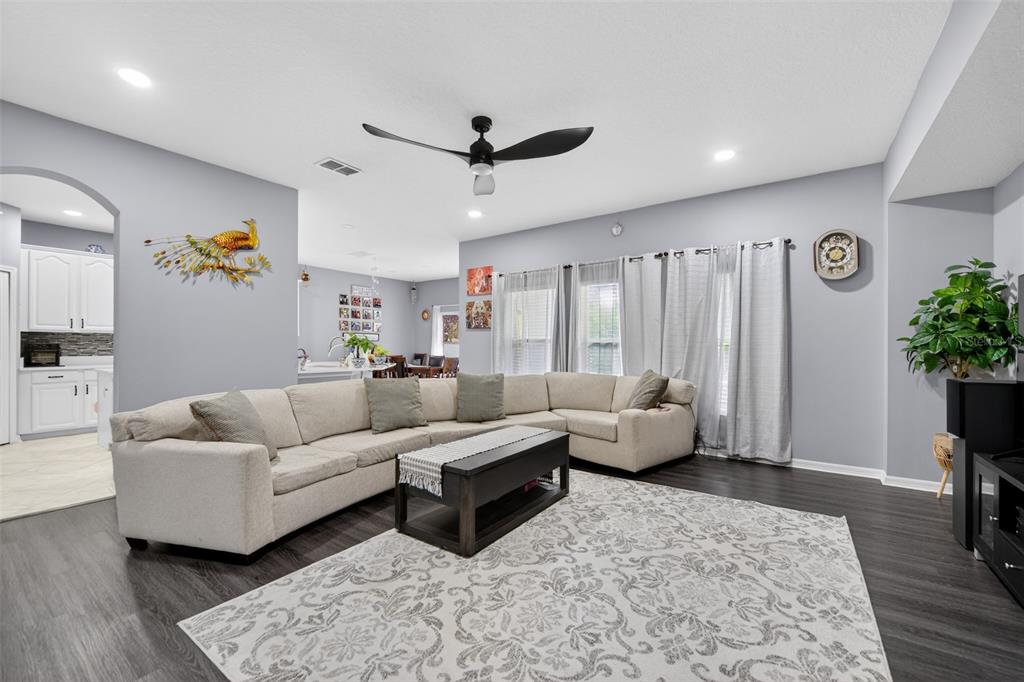A living room features a large sectional sofa, a coffee table, and a patterned rug — 3651 DAYDREAM PLACE, ST CLOUD, FL
