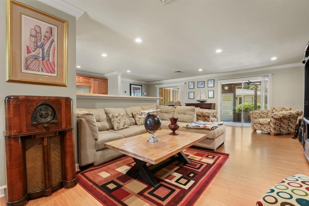 A living room features a sectional sofa, wooden coffee table, area rug, and vintage radio — 200 CROOKED OAK COURT, LONGWOOD, FL