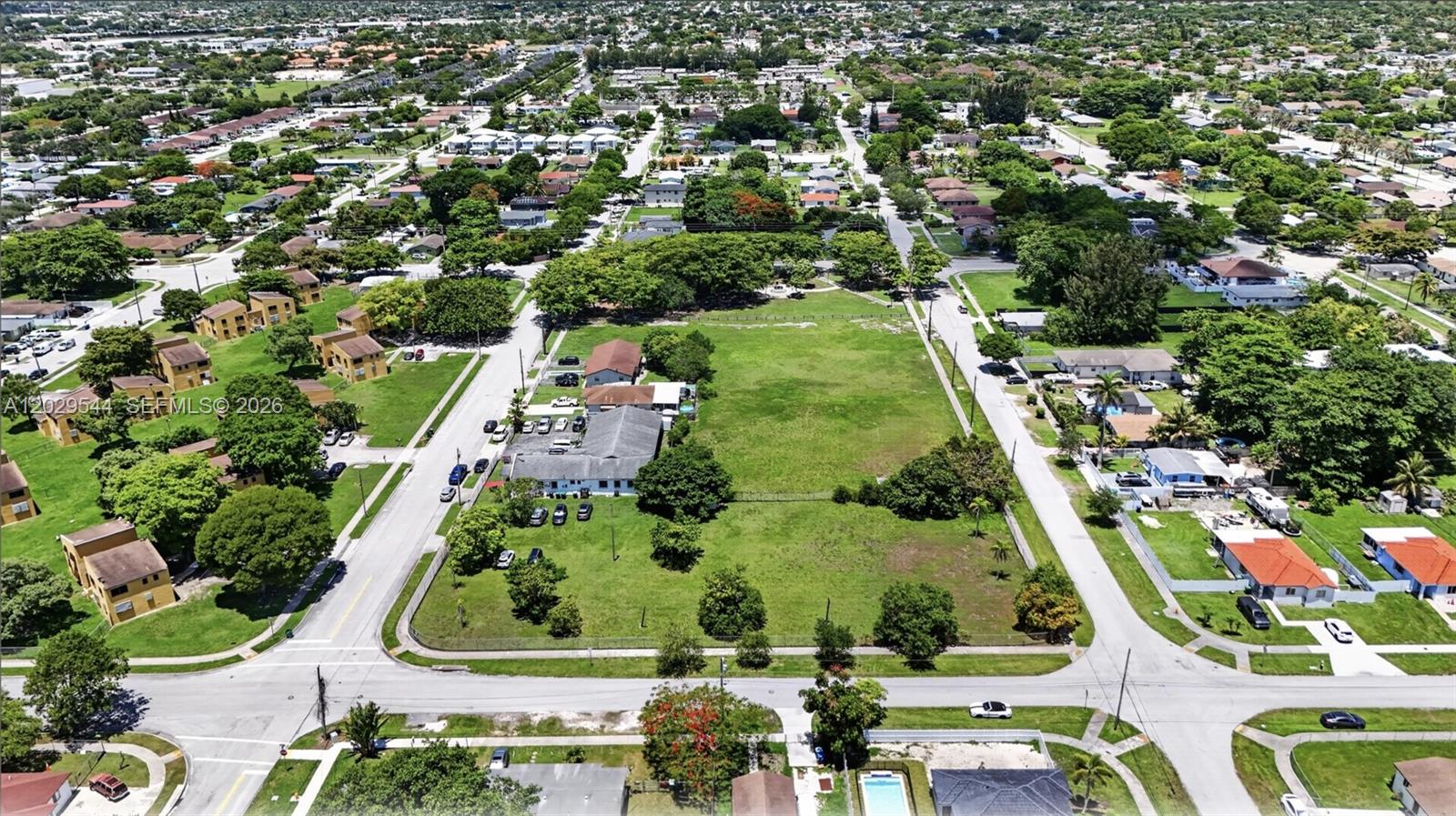 An aerial view shows a large vacant lot adjacent to a building and residential neighborhood — 10330 SW 178th St, Miami FL 33157, MIAMI, FL