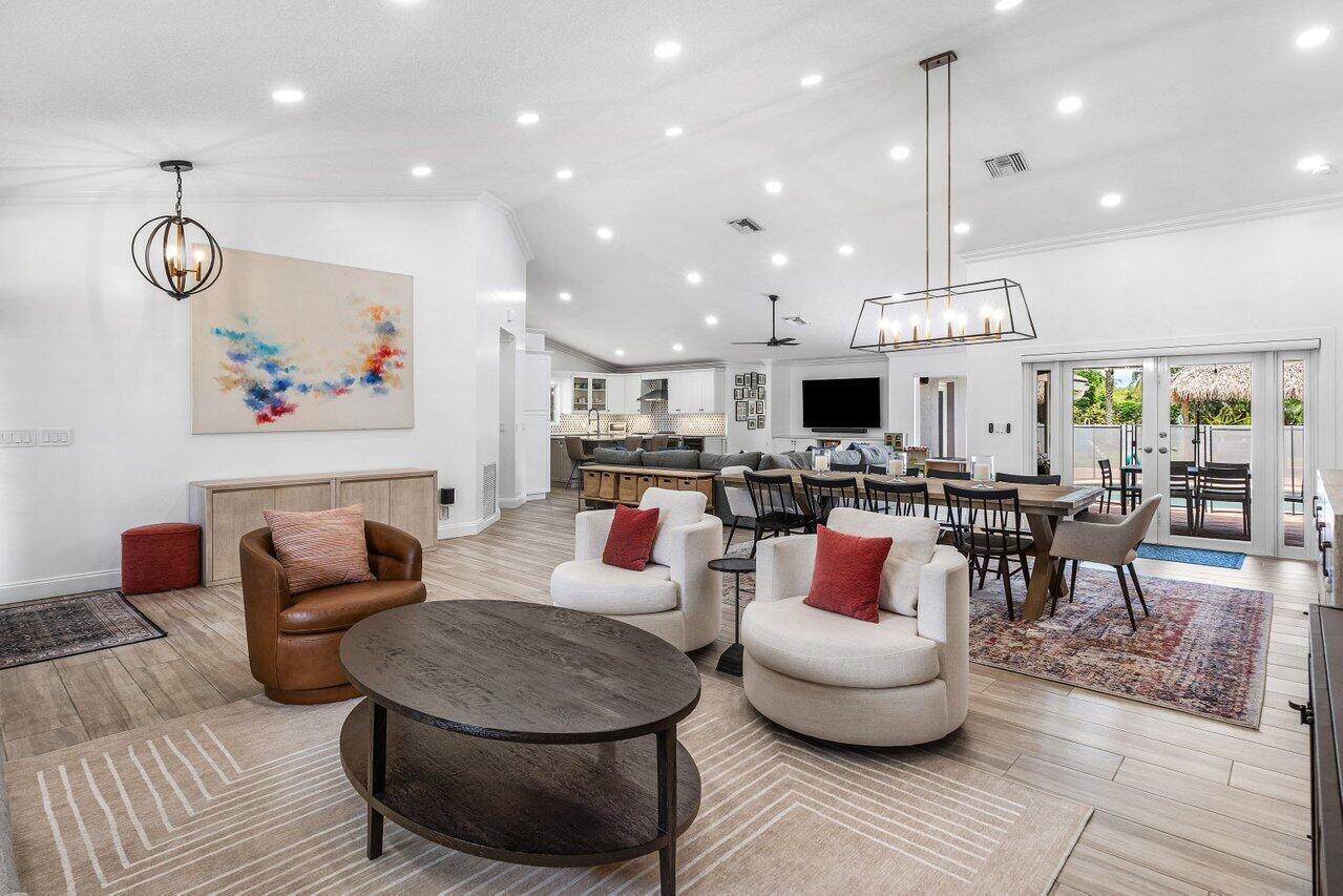 An open-concept living and dining area features light wood floors, recessed lighting, and modern furniture — 990 NW 8th Street, Boca Raton FL 33486, BOCA RATON, FL