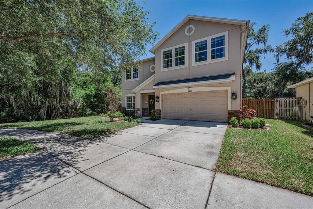 A home office features built-in white bookshelves, a beige armchair, and dark hardwood flooring — 5820 TULIP FLOWER DRIVE, RIVERVIEW, FL
