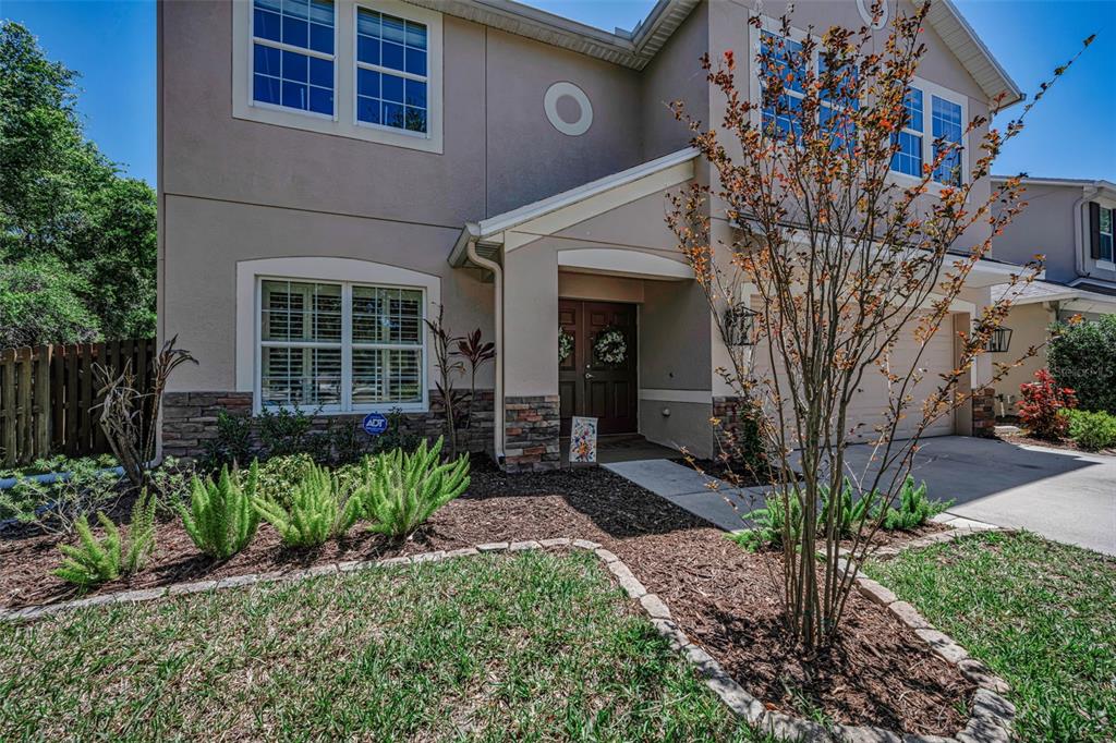 A living room with a sectional sofa, round coffee table, and open kitchen in background — 5820 TULIP FLOWER DRIVE, RIVERVIEW, FL
