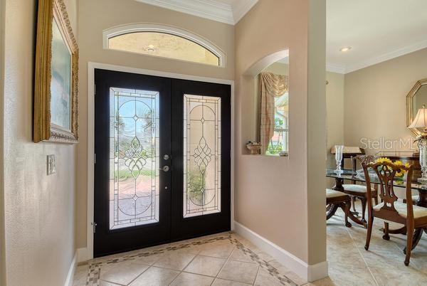 An entryway with a double front door, arched transom window, and tile flooring — 9477 CEDAR RIDGE LANE, SARASOTA, FL