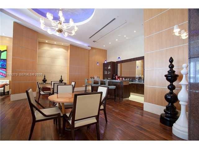 A dining area with a round table, chairs, and a bar counter in a modern room — 253 NE 2nd St # 509, Miami FL 33132, MIAMI, FL