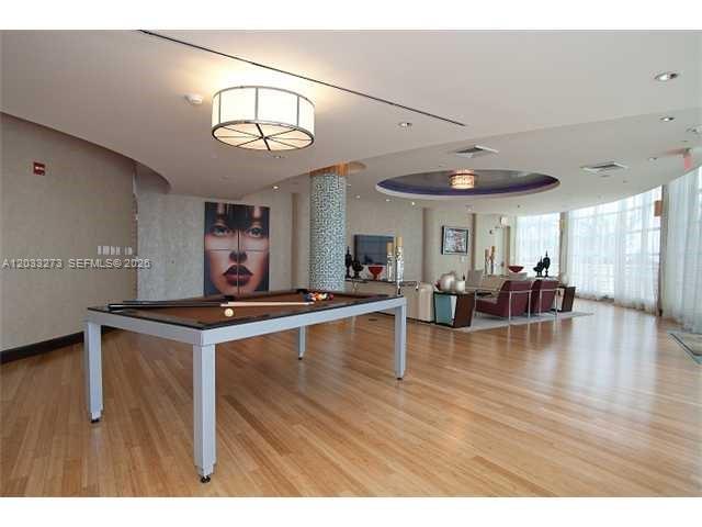 A spacious lounge area features a pool table, hardwood floors, and modern recessed lighting — 253 NE 2nd St # 509, Miami FL 33132, MIAMI, FL
