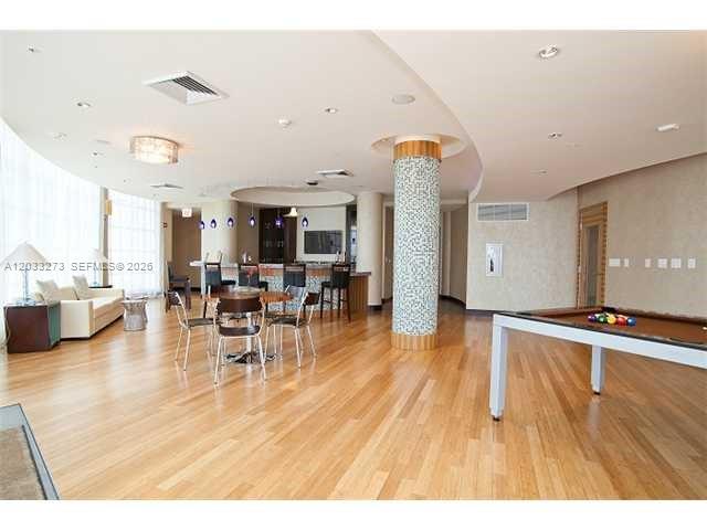 A spacious lounge features hardwood floors, a pool table, and a bar with barstools — 253 NE 2nd St # 509, Miami FL 33132, MIAMI, FL