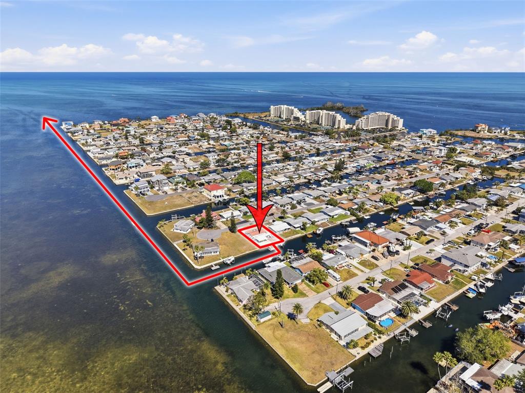 An aerial view shows a waterfront house highlighted with a red outline and arrow — 13520 ALLYN DRIVE, HUDSON, FL