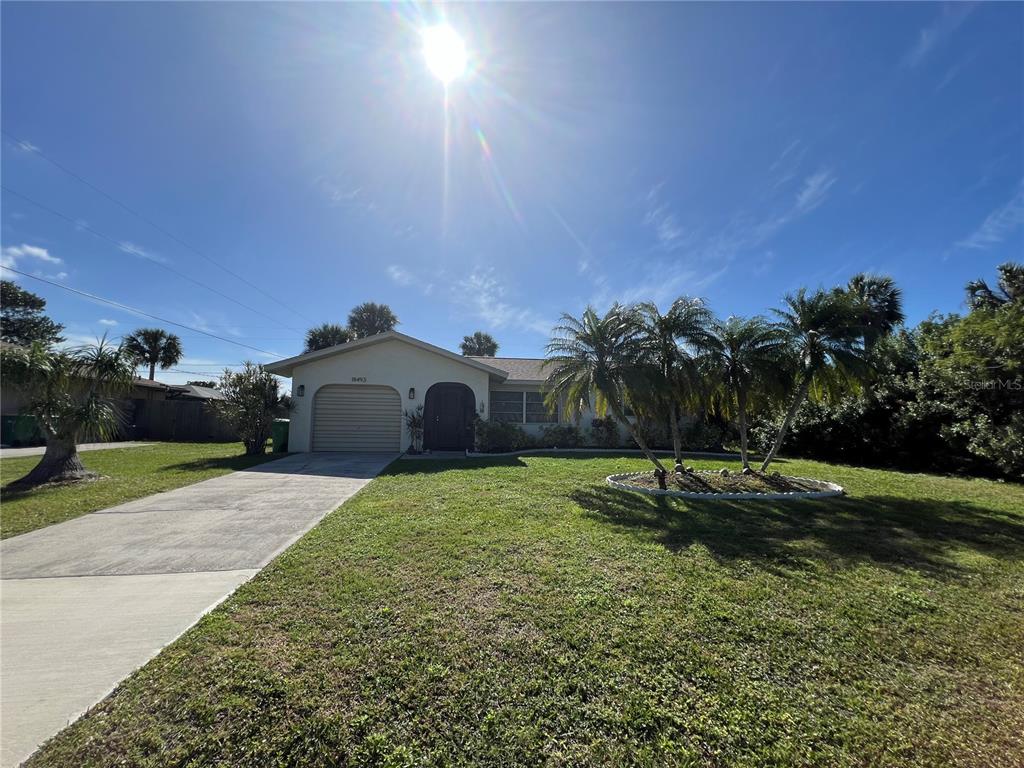 A single-story house with a garage, a concrete driveway, and palm trees in the front yard — 18493 LAKE WORTH BOULEVARD, PORT CHARLOTTE, FL