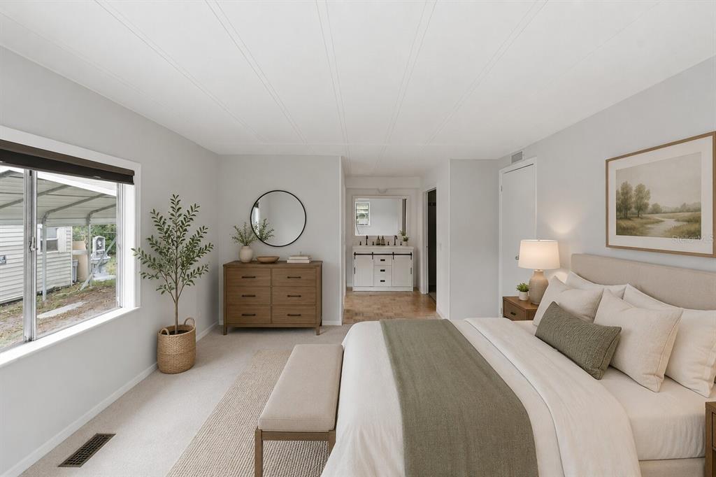 A bedroom features a bed, a wooden dresser with a mirror, and an attached bathroom — 4128 WOODLAND CIRCLE, DELAND, FL