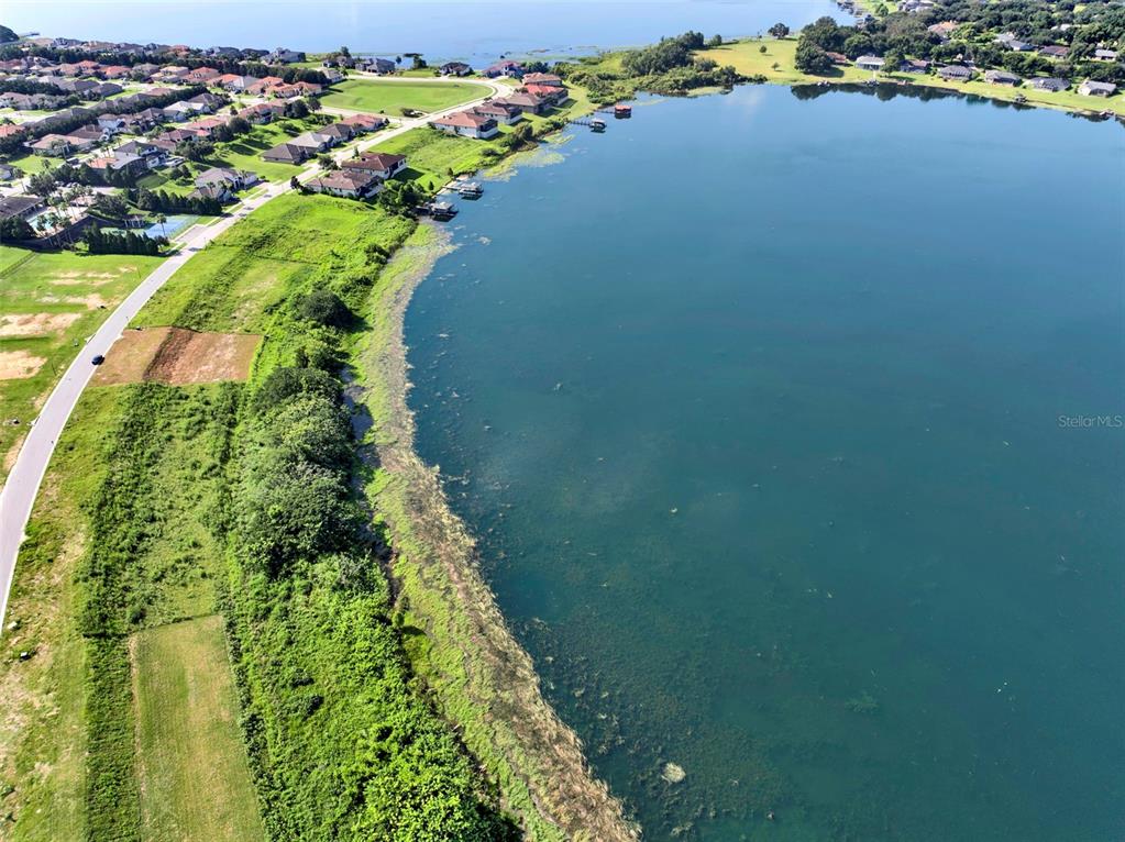 An aerial view shows a large lake bordered by residential homes and green vegetation — 4283 JULIANA LAKE DRIVE, AUBURNDALE, FL
