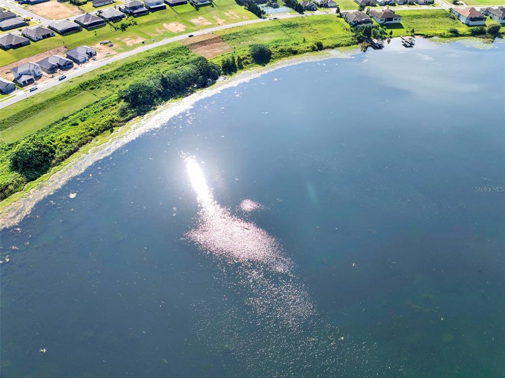 An aerial view shows a large lake bordered by a residential neighborhood and green space — 4283 JULIANA LAKE DRIVE, AUBURNDALE, FL