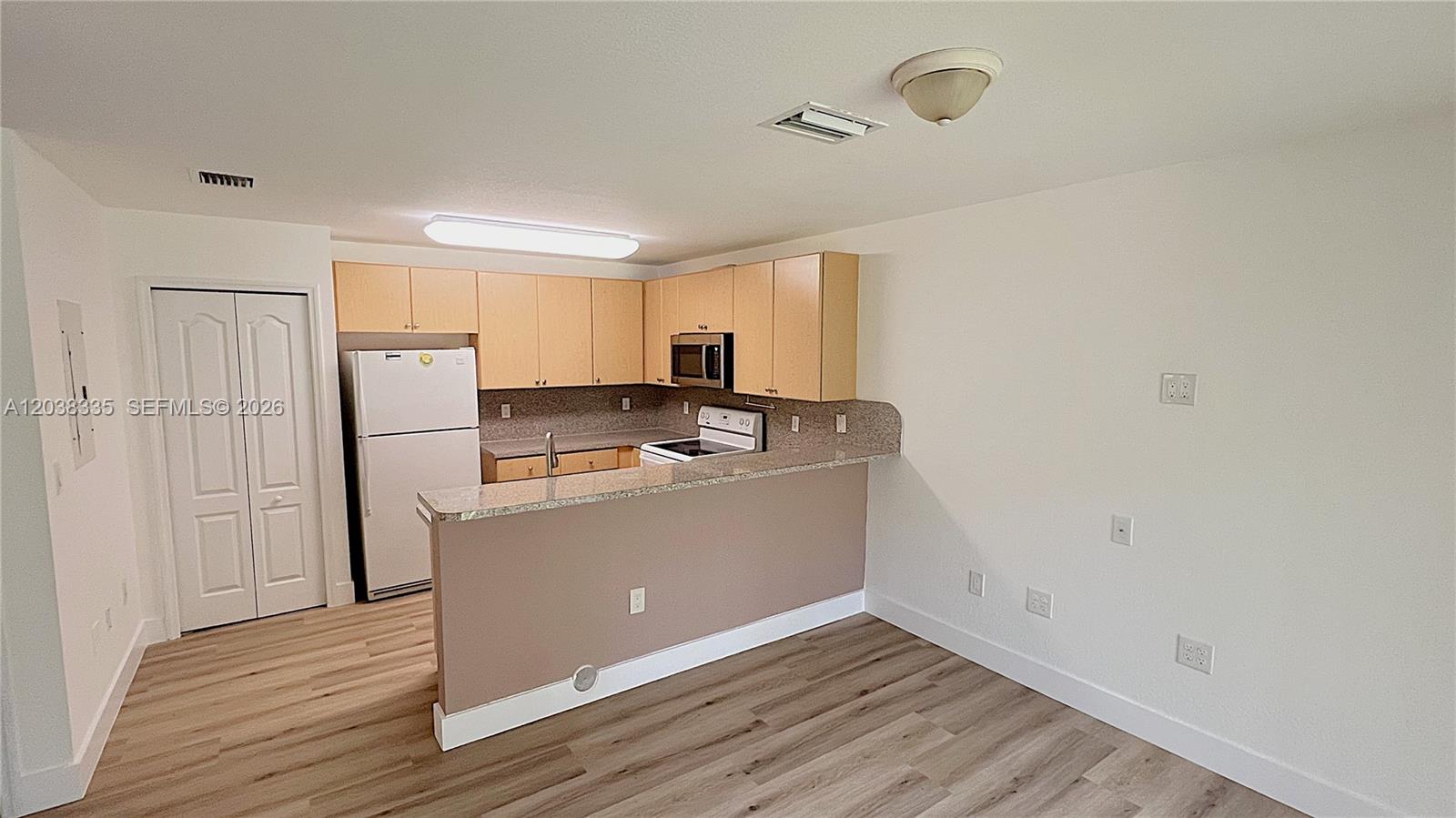 A kitchen features light wood cabinets, granite countertops, and a breakfast bar — 22721 SW 88th Pl # 19, Cutler Bay FL 33190, CUTLER BAY, FL
