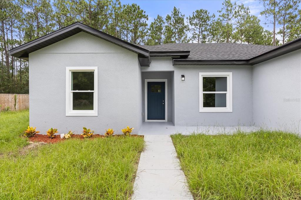 An aerial view shows a single-story house with a gray roof and blue garage door — 6211 SW 144TH STREET RD, OCALA, FL