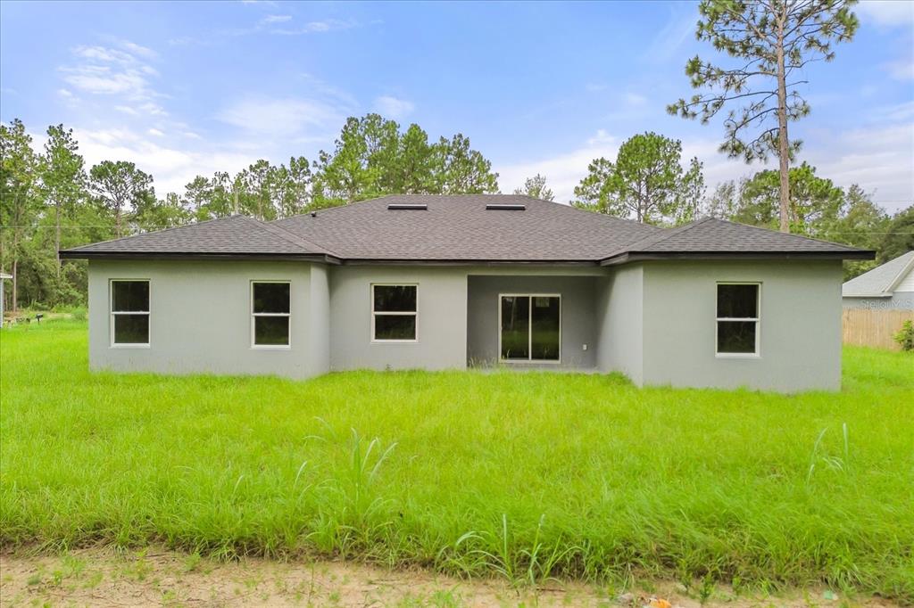 An aerial view shows a single-story house with a gray roof and a concrete driveway — 6211 SW 144TH STREET RD, OCALA, FL
