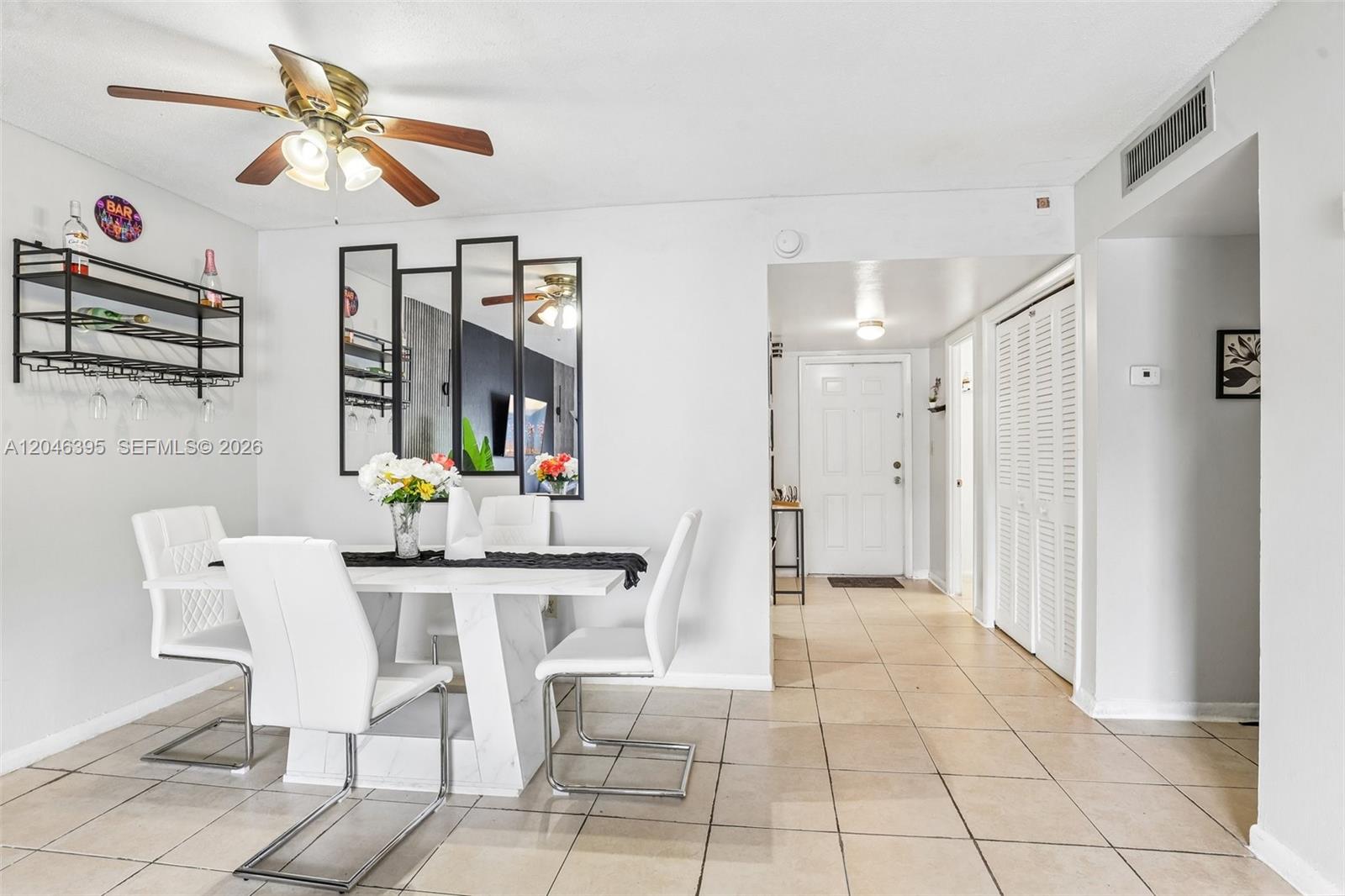 A dining area features a white table, four chairs, a ceiling fan, and tiled floors — 15225 NE 6th Ave # B208, Miami FL 33162, MIAMI, FL