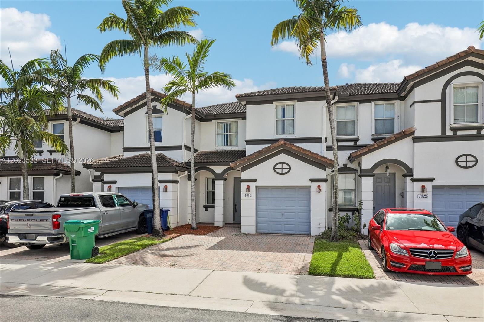 A row of two-story townhouses with stucco exteriors, tile roofs, and attached garages — 7616 NW 114th Path # 7616, Doral FL 33178, DORAL, FL