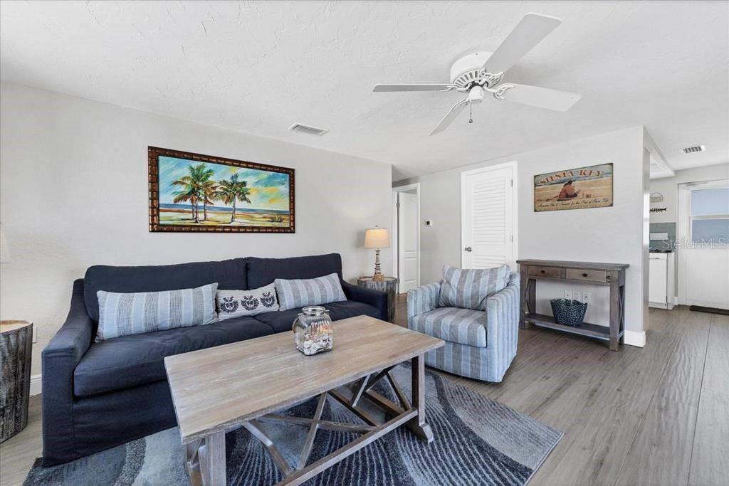 A living room features a dark blue sofa, a striped armchair, and a wooden coffee table — 6154 MIDNIGHT PASS ROAD UNIT B05, SARASOTA, FL