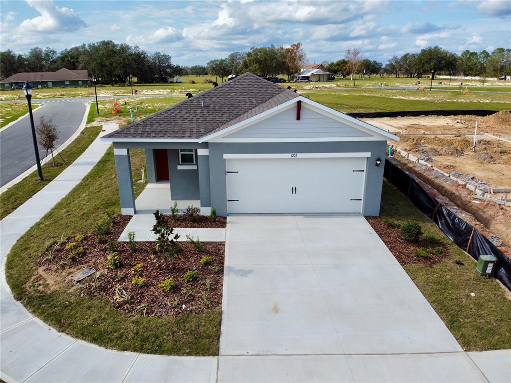 An aerial view of a gray single-story house with a white garage and red door — 1703 POST OAK DRIVE, DAVENPORT, FL