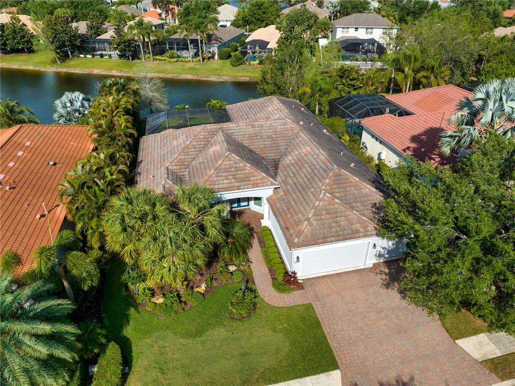 An aerial view shows a single-story house with a tiled roof, driveway, and backyard pool — 14717 BOWFIN TERRACE, BRADENTON, FL