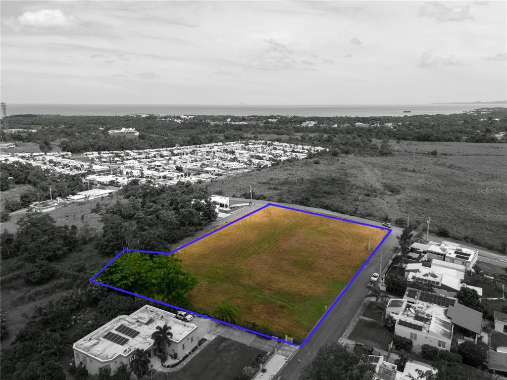 An aerial view shows a vacant, rectangular lot outlined in blue within a residential area — URB. MIRADERO INTERIOR CALLE PLAYAS, CABO ROJO, PR
