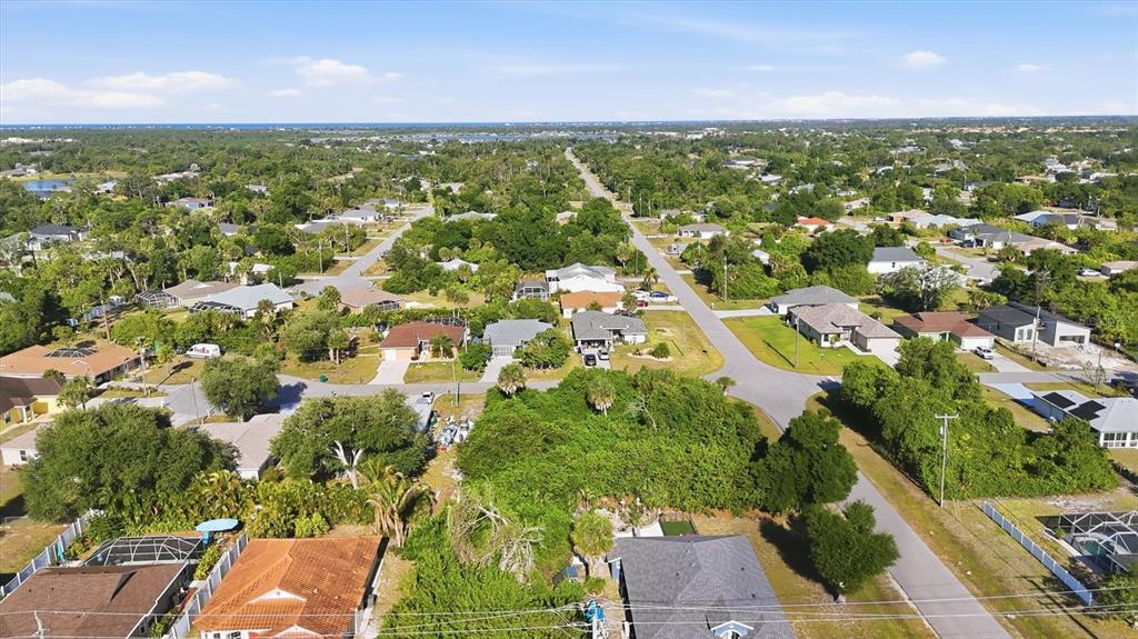 An aerial view shows a residential neighborhood with houses, green trees, and paved streets — 109 SIDNEY COURT, ROTONDA WEST, FL