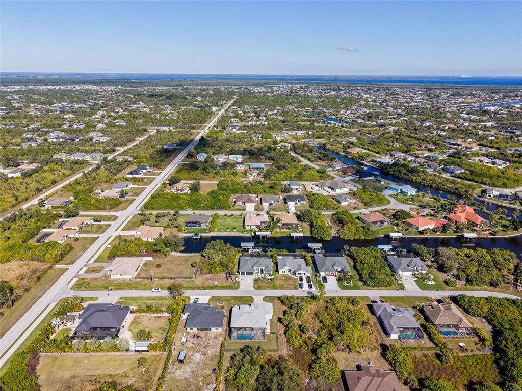 An aerial view shows suburban houses with swimming pools situated along a canal — 9309 PANAMA CIRCLE, PORT CHARLOTTE, FL