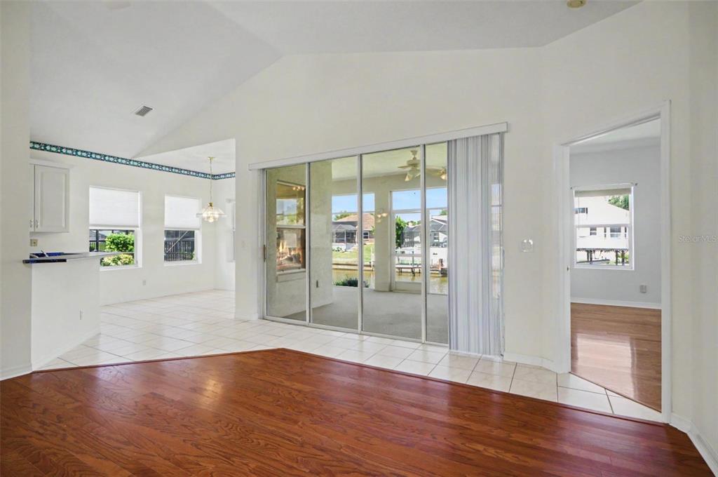 A living room with hardwood floors, tile, sliding glass doors, and a view of water — 40 COLUMBIA LANE, PALM COAST, FL