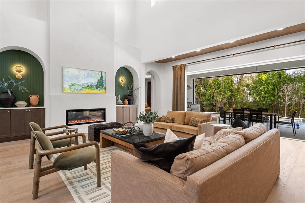 A living room features a fireplace, arched built-ins, and a large sliding door to a patio — 2080 LAKE MARKHAM ROAD, SANFORD, FL