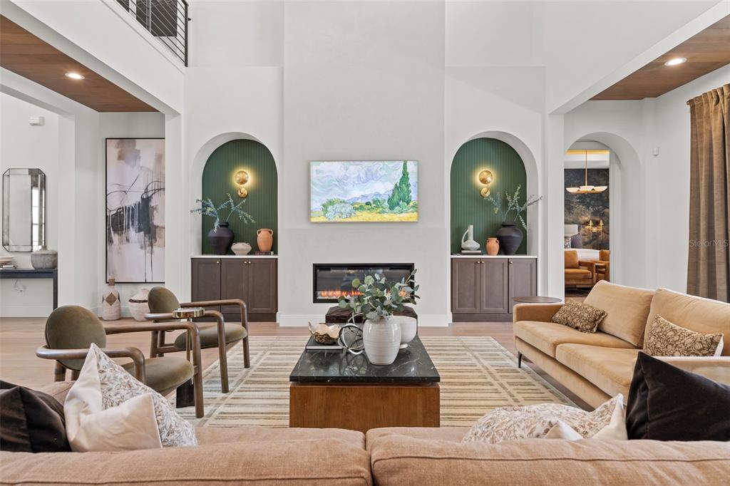 A living room features a fireplace between two arched green niches and a tan sofa — 2080 LAKE MARKHAM ROAD, SANFORD, FL